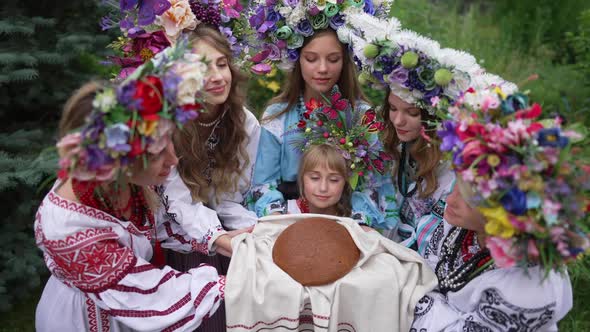 High Angle View of Charming Ukrainian Girl Looking at Camera Showing Loaf of Bread on Ukrainian alt