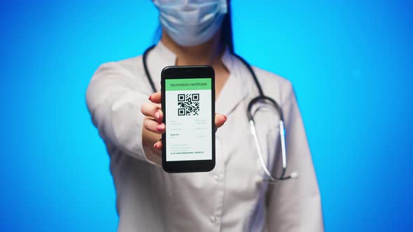 Woman Doctor in Medical Uniform Showing Vaccination Passport with Qr Code on Phone International alt