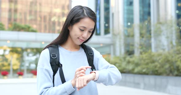 Woman use of smart watch in city alt