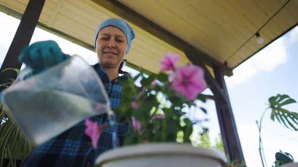 Woman At Home In The Attic Plants Beautiful Flowers In Pots alt