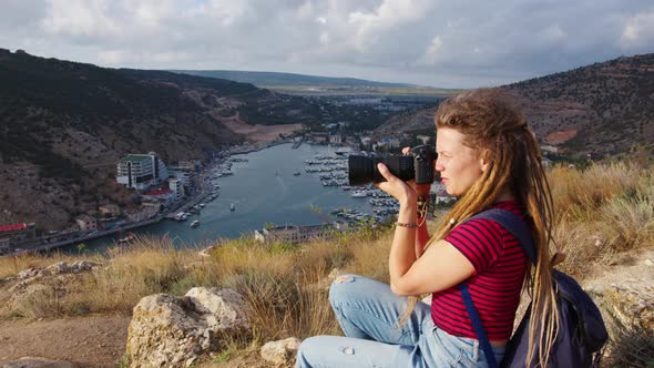 Girl with Dreadlocks Takes Pictures of River in Gorge alt