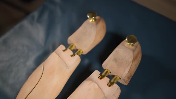 Two Used Shoe Trees Displayed on Blue Leather at Cobbler Workshop or at Home alt