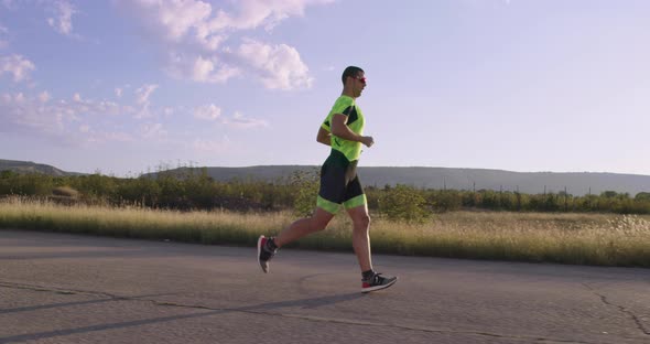 Triathlon  Male Triathlete Running in Triathlon Suit Training for Ironman Race alt