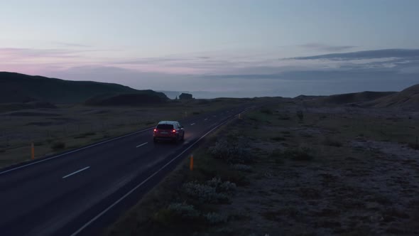 Aerial View Car Driving Along Empty Country Road at Sunset alt