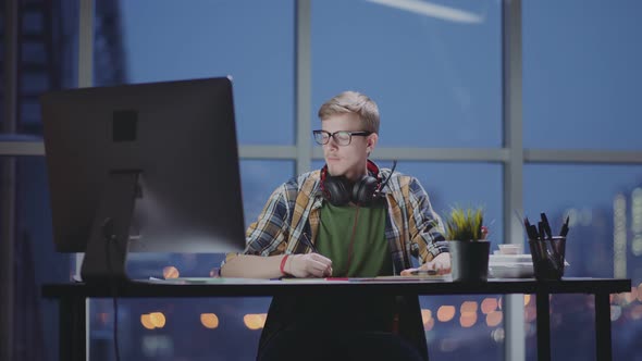 Male Designer Works on Personal Computer Night in Empty Office