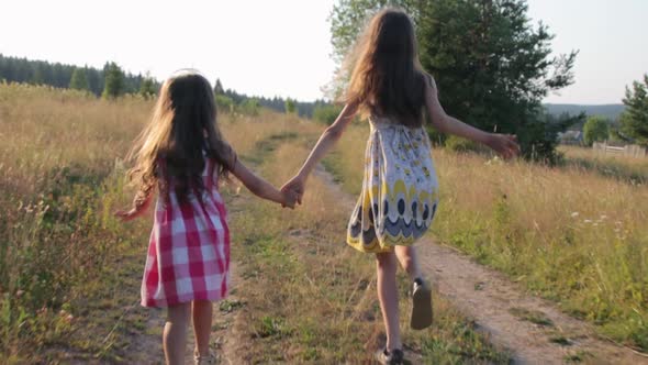 Two little girls running on rural road