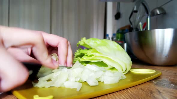 A woman cuts cabbage into a light, healthy salad