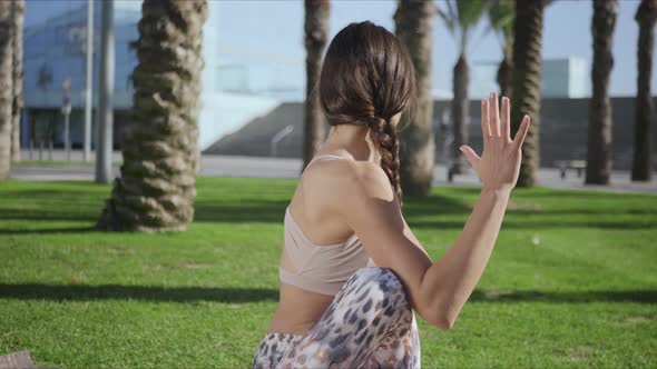 Woman Doing Seated Spinal Twist Pose on Mat. Girl Performing Yoga in Park alt