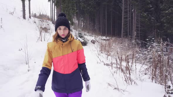 Closeup Profile of Young Woman Walking in Winter Forest During the Snow Falling alt