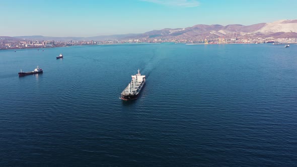 Flycam Films Long White Freight Vessel Crossing Clear Water alt