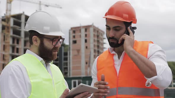Engineer Speaks on Mobile Phone on Construction Site and Checks the Work of the Worker. Builder alt