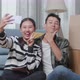 Young Asian Couple With Cardboard Boxes Taking Photo By Smartphone After Moving Into A New House - VideoHive Item for Sale