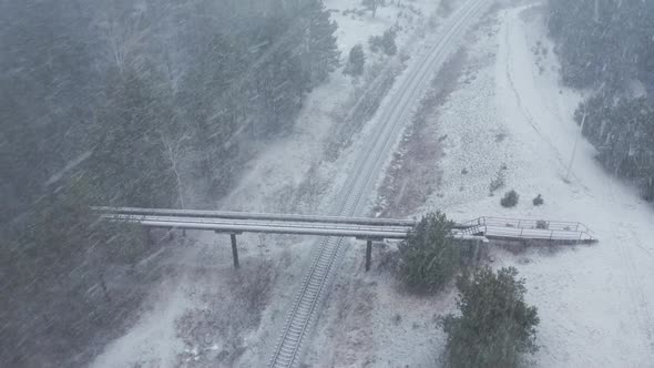 AERIAL: Rotating Shot of Overpass Bridge with Railway on a Snowstorm alt