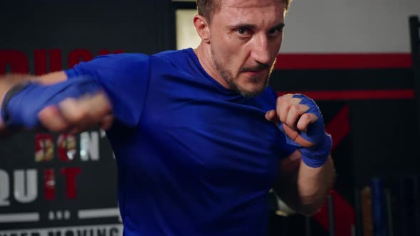 4K Caucasian man do sport training boxing exercise with punching the air at gym. alt