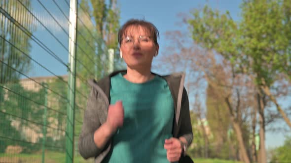 Mature Active Woman Running Outdoor Near Stadium alt