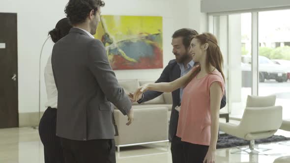 Clients shaking hands with business consultants in lobby