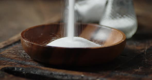 Salt Is Poured Into a Wooden Plate