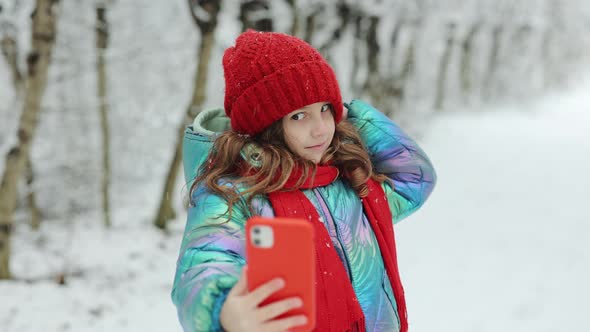 Cute Little Girl Taking a Selfie in the Winter Forest