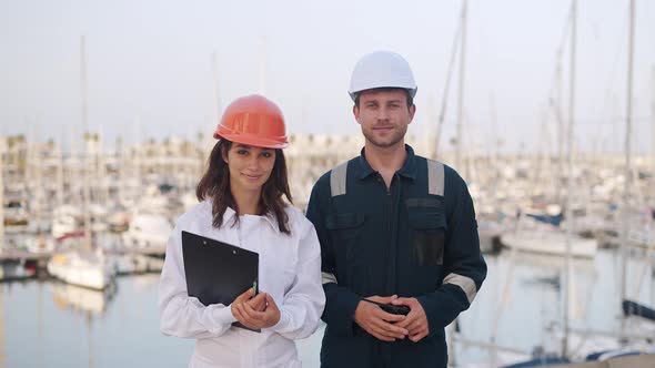 Woman and Man Yacht Sailors Standing at Marina alt