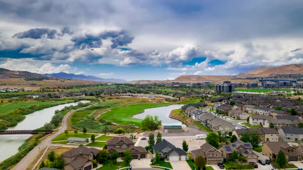 Dramatic cloudscape above a suburban area and golf course - aerial hyper lapse alt