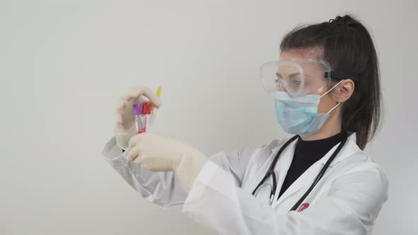 Doctor with Face Mask and Protective Glasses Working with SARS-CoV-2 in Laboratory. COVID-19 alt