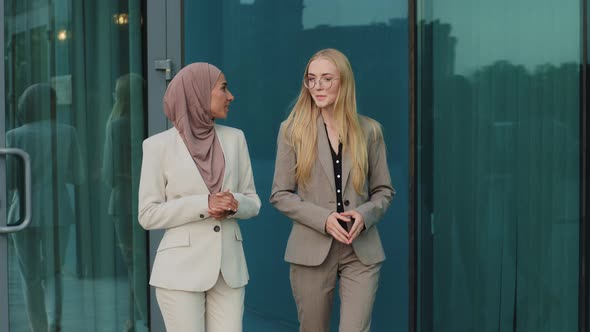 Indian Girl in Hijab Consults with Colleague Young European Woman During Office Break alt