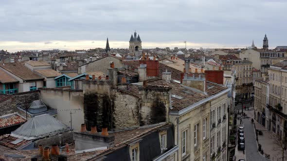 City of Bordeaux France rooftops showing Cailhau City Gate and pigeon flocks flying, Aerial pedestal alt