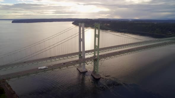 Wide aerial shot pulling away from Tacoma Narrows Bridge at sunset, circa 2015. alt