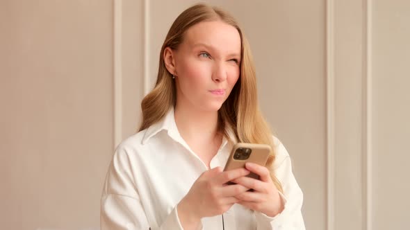 Young woman pensively thinks having doubts and using a mobile phone, chatting in social media alt