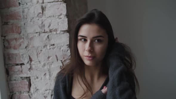 Portrait of Passionate Brunette in Lingerie Caresses and Smiles in Raw Building alt