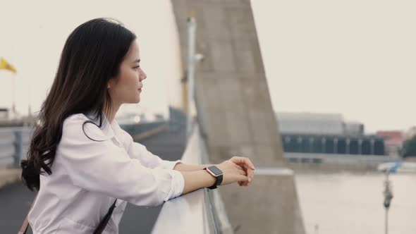 Portrait of attractive young Asian woman standing on the bridge.