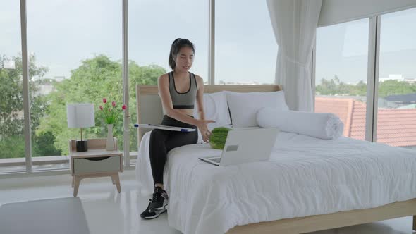 Young woman teaching online workout through social media in the room