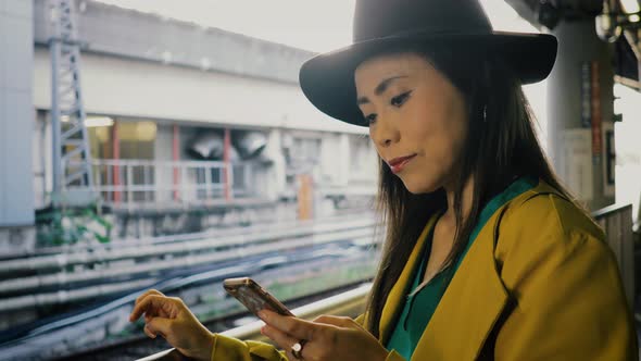 Japanese woman waiting for a train in Tokyo Japan alt