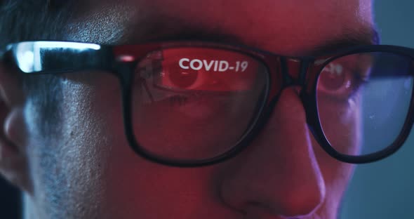 Closeup of Man Working at a Computer Reflected in Glasses Warning of COVID 19 alt