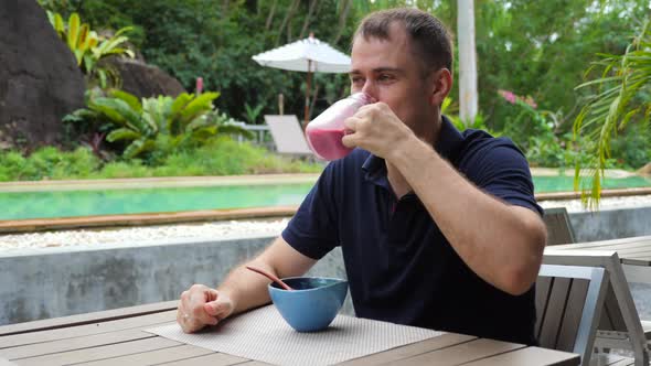 Happy Handsome Man Drinking Freshly Smoothie From Fresh Fruit and Berries alt