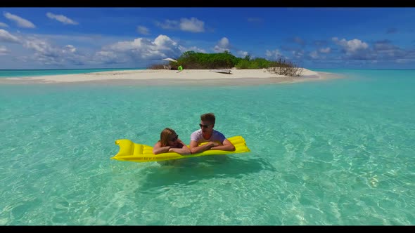 Guy and girl sunbathing on tranquil bay beach holiday by turquoise ocean with white sand background  alt