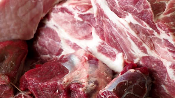 Different types of raw pork meat and beef. Raw meat on wooden table. 