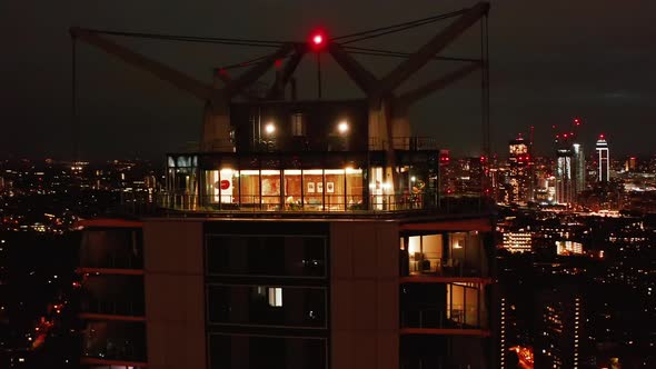 Orbit Shot Around Illuminated Top of Modern Tall Building alt