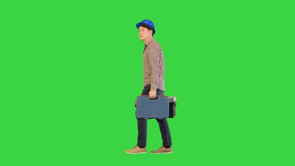 A Manual Worker with a Toolbox Walking on a Green Screen Chroma Key