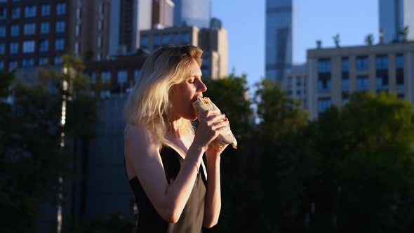 women eats fast food in big city