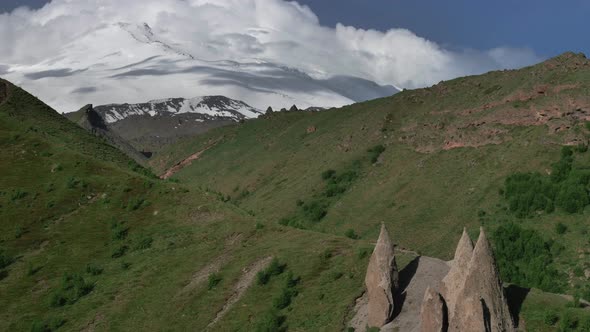 Mount Elbrus and green hills at sunny summer day.