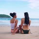 Back of Happy Smiling Beautiful Asian Women in Swimwear Sitting and Laughing on the Tropical Beach - VideoHive Item for Sale