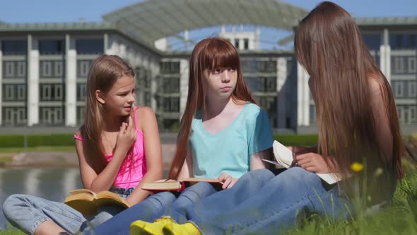 Group of Diverse Teen School Children Reading Books in Park alt
