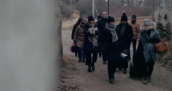 Refugees Migrating In Cold Through Ruins During War Crisis alt