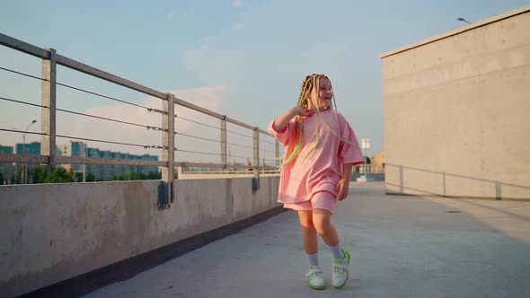 Girl dancing moving on camera outdoors. Positive child smile looking at camera walking and dance