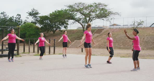 Female friends enjoying exercising at boot camp together alt