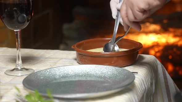 Traditional catalan Christmas food Cannelloni with bechamel on a plate. Fireplace in the background. alt