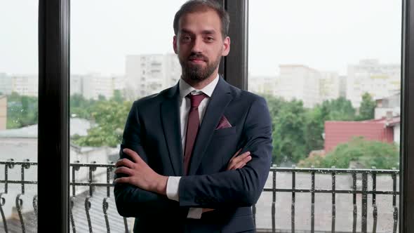 Portrait of Smiling Businessman with His Hands Crossed alt