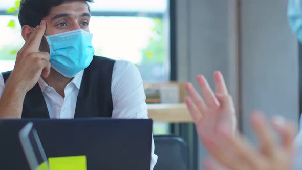 business meeting Freelance caucasian male and asian female putting protective face mask alt