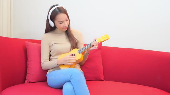 Young asian woman play ukulele